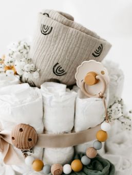 A light-colored diaper cake is a beautiful, modern and necessary gift to take to babyshows, for example, or to remember a coworker.