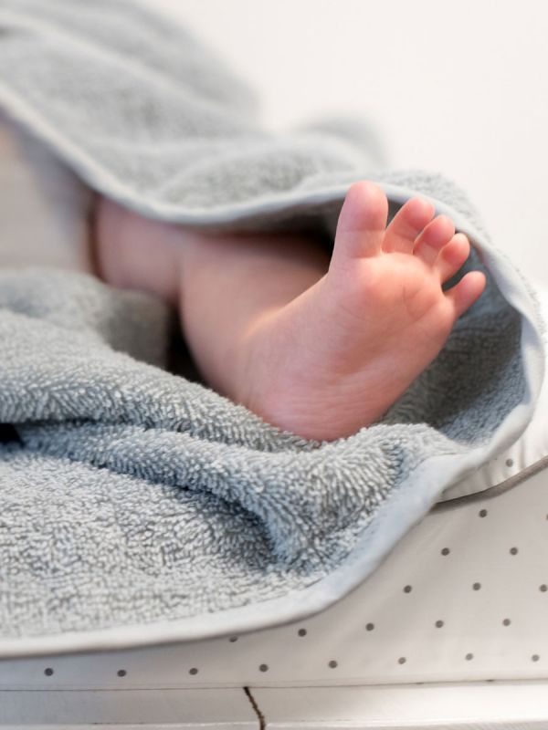 Light-colored hooded towel for babies to shower and bath tubs moments.