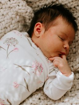 Embe logsleeve swaddle Pink Clustered Flowers. The intelligent Embé zipper and swaddle design help to use the swaddle correctly. It prevents over-tightening of the pelvic area, which can cause hip dysplasia over a longer period of time.