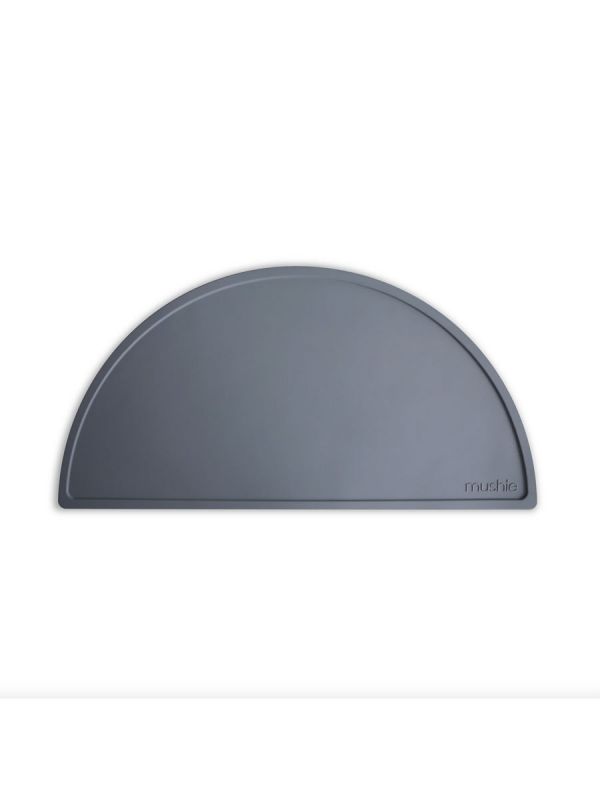 Mushie silicone place mat. The place mat stays firmly on the table and keeps the dishes and mess in one place.