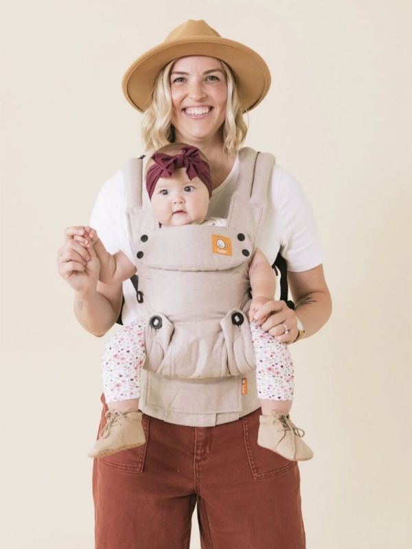 TULA Explore Baby Carrier sand. Multiple positions to carry baby including front facing out, facing in, and back carry. Each position provides a natural, ergonomic position.