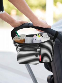 This insulated beverage and essentials caddy stretches to hold bottles and coffee cups securely, while providing easy access to your most important items. Includes a detachable wristlet for errands and a headphone port for hands-free calls.