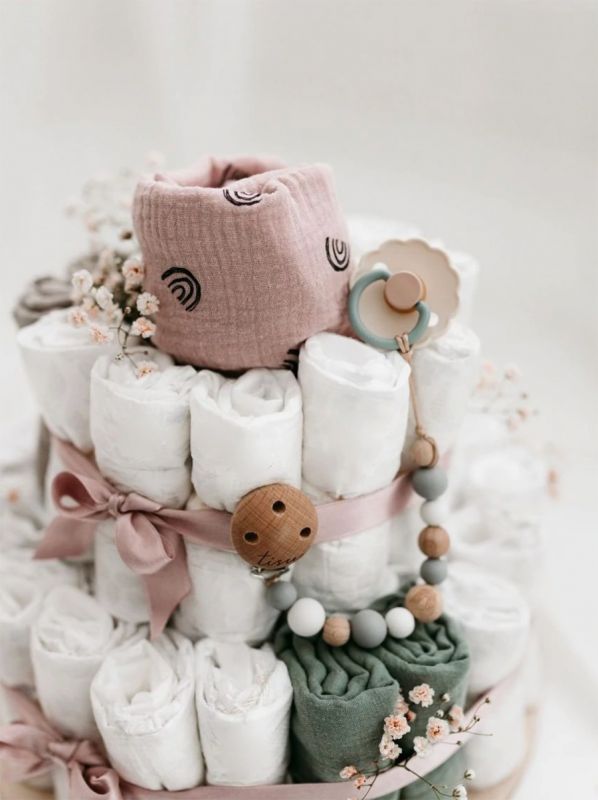 A light-colored diaper cake is a beautiful, modern and necessary gift to take to babyshows, for example, or to remember a coworker.