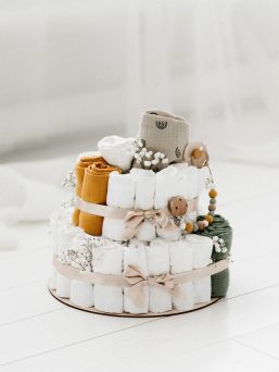 A light-colored diaper cake is a beautiful, modern and necessary gift to take to babyshows, for example, or to remember a coworker.