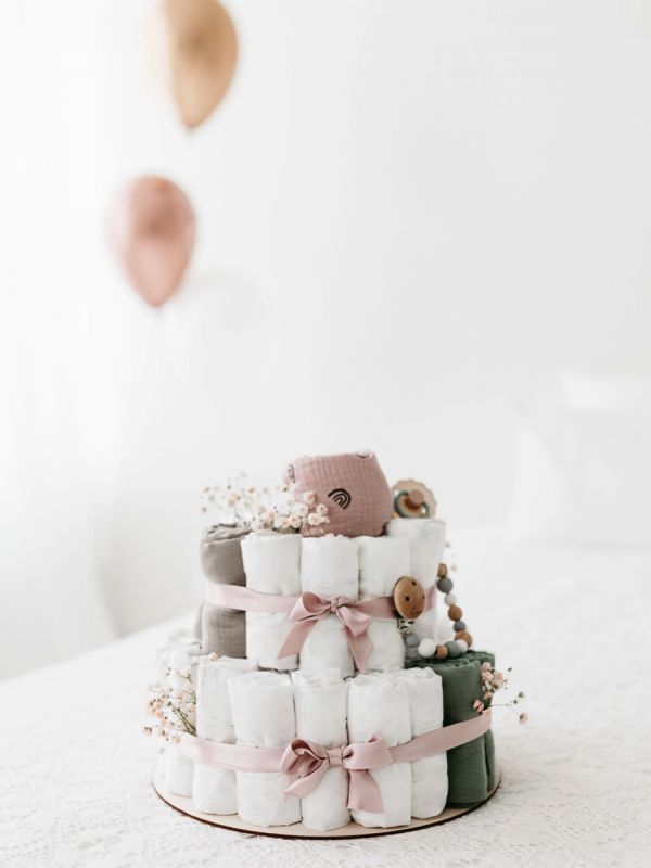 A light-colored diaper cake is a beautiful, modern and necessary gift to take to babyshows, for example, or to remember a coworker.